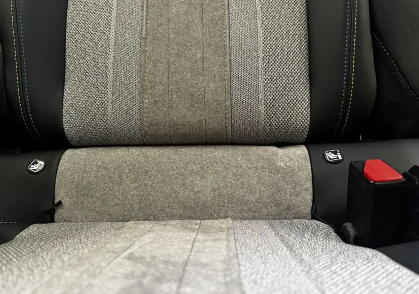 Gros plan sur la banquette arrière grise du Peugeot E-2008 électrique GT Pack avec attaches Isofix visibles.