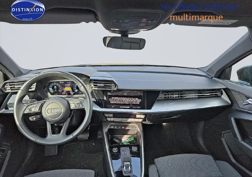 Vue intérieure avant de l'Audi A3 Sportback 2024, tableau de bord moderne avec écran tactile et volant cuir multifonction.