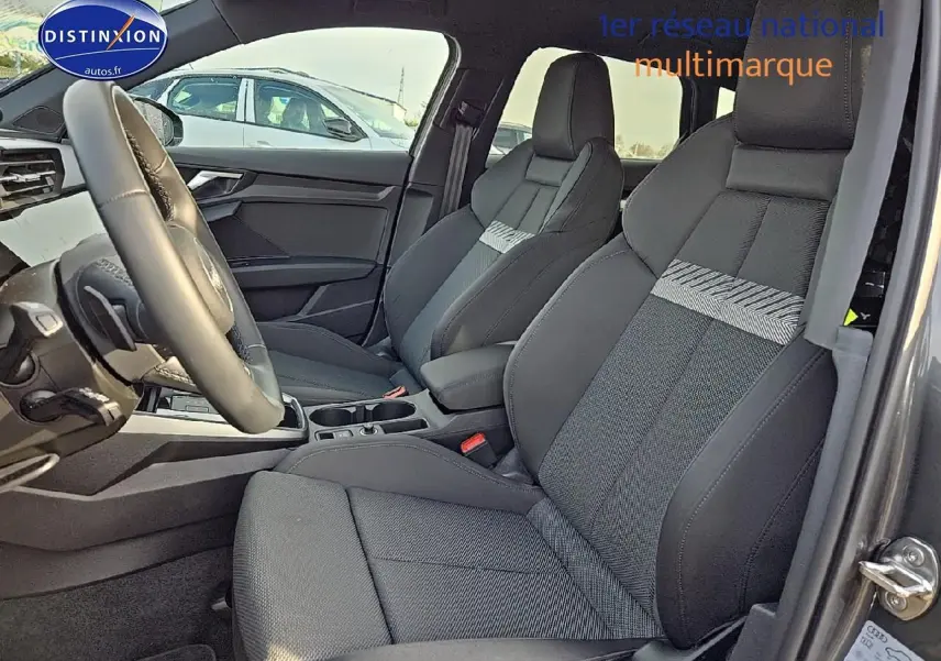 Intérieur de l'Audi A3 Sportback 2024 en gris Daytona, vue côté gauche sur les sièges avant sport avec accoudoir central.