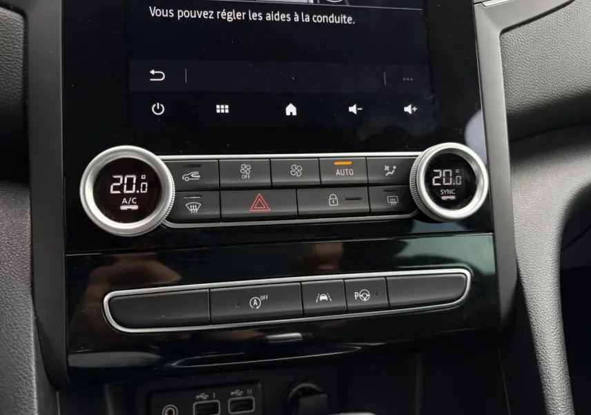 Vue rapprochée du tableau de bord central de la Renault Mégane Break 2024, avec commandes climatisation digitale à 20°C et écran tactile Easy Link.
