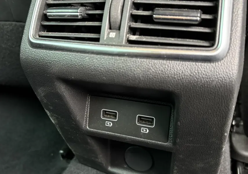Prise USB double en gros plan sous la grille d'aération arrière d'une Renault Mégane Break gris Highland 2024.