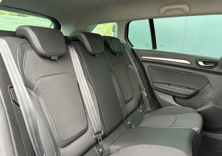 Vue latérale droite de la banquette arrière en tissu noir avec surpiqûres blanches dans une Renault Mégane Break 2024.
