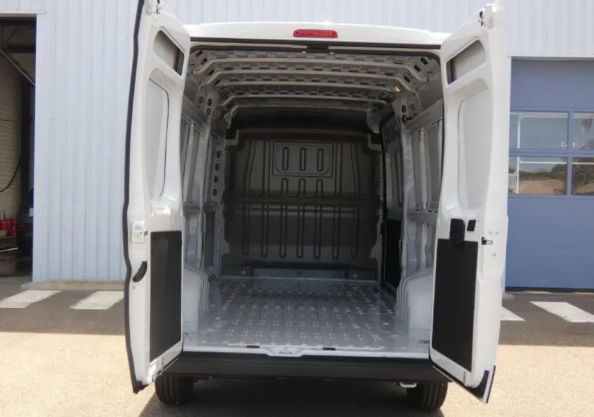 Vue arrière du Citroën Jumper blanc 2025 avec portes arrière ouvertes dévoilant l’espace de chargement vide.