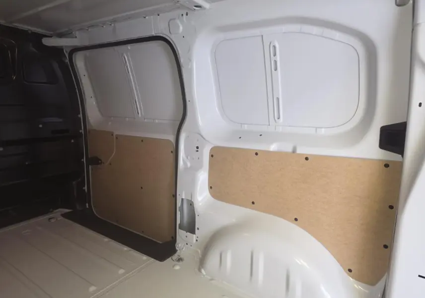 Vue intérieure du coffre blanc de l'Opel Vivaro 2025 avec panneaux de protection en bois clair sur les parois.