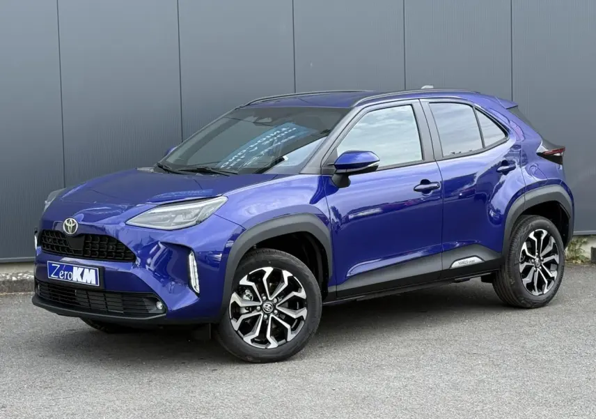 Toyota Yaris Cross bleu Genievre en 3/4 avant droit avec jantes alliage et protections noires sur carrosserie