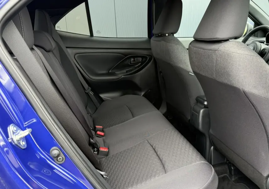 Vue intérieure côté gauche des sièges arrière noirs d’une Toyota Yaris Cross 1.5 Hybrid 116 Design bleu Genievre.