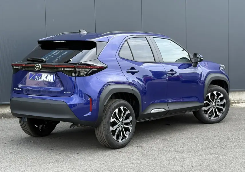 Toyota Yaris Cross bleu Genievre en 3/4 arrière droit, avec jantes noires et toit noir contrasté.