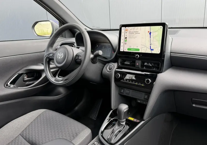 Vue intérieure côté conducteur de la Toyota Yaris Cross 1.5 Hybrid 116 Design avec écran tactile et volant cuir.