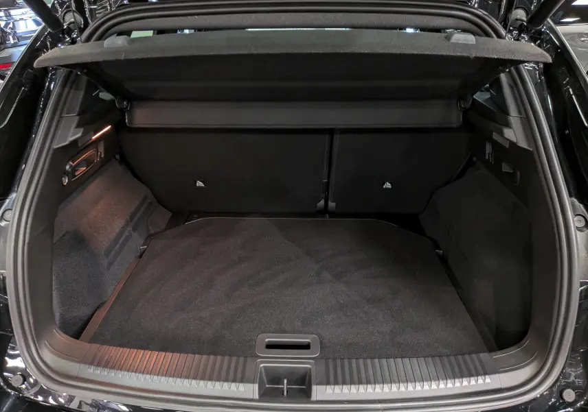Coffre ouvert vu de l'arrière d'un Renault Austral noir, montrant un espace de chargement propre et spacieux.