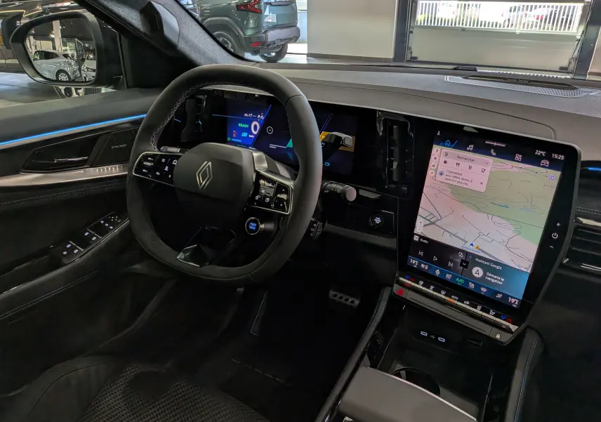 Vue intérieure côté conducteur du Renault Austral noir, avec volant multifonction et grand écran tactile central affichant la navigation.