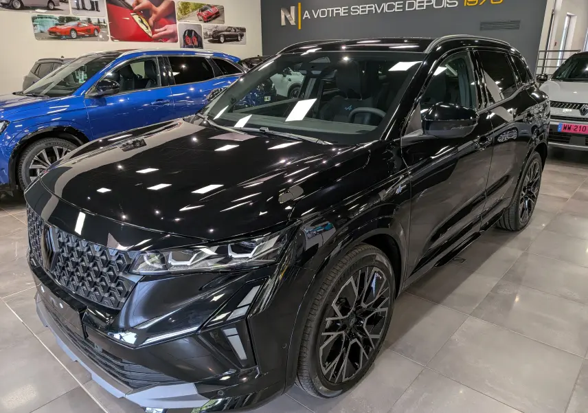 Renault Austral full hybrid noir en 3/4 avant droit, avec calandre distinctive et jantes noires stylées en showroom.