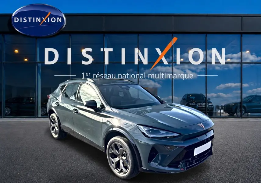 Vue 3/4 avant droit d'un SUV CUPRA Formentor 1.5 etsi hybrid bleu fjord avec jantes 18 pouces devant un showroom Distinxion.