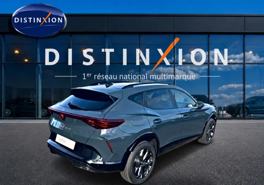 Vue 3/4 arrière droite d'une CUPRA Formentor bleu fjord avec jantes noires devant un showroom Distinxion.