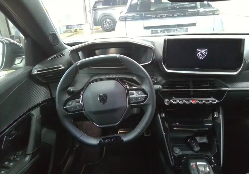 Vue intérieure centrée sur le volant GT et l’écran tactile du tableau de bord du Peugeot 2008 gris Selenium.