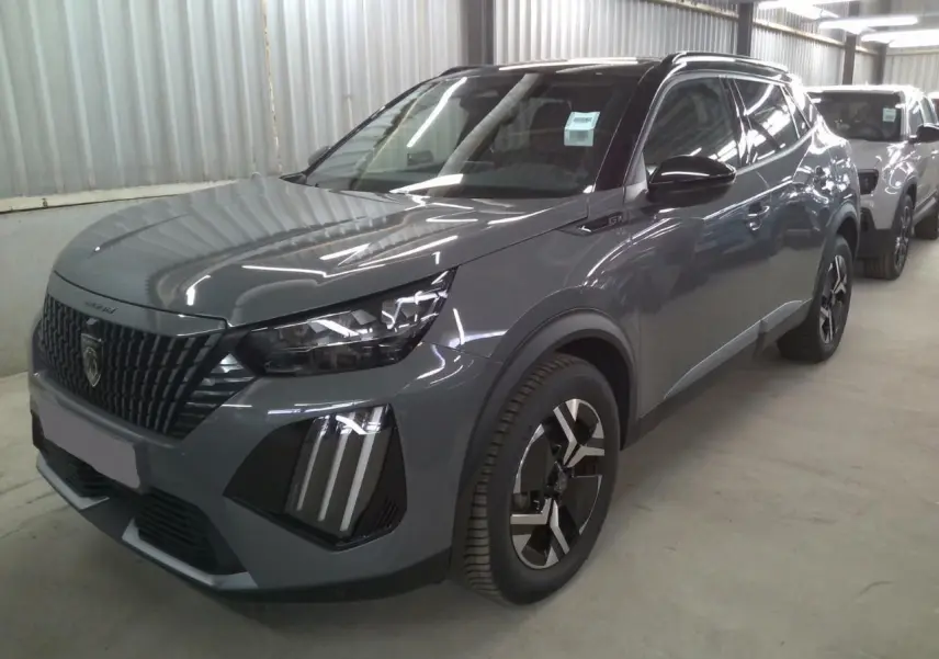 Peugeot 2008 1.2 Hybrid 145ch GT gris selenium en 3/4 avant droit avec barres de toit noires visibles.