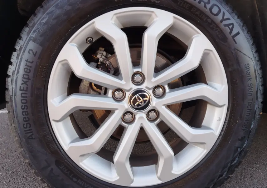 Gros plan sur la jante alliage argentée 17 pouces avec logo Toyota, montée sur pneu AllSeasonExpert 2.