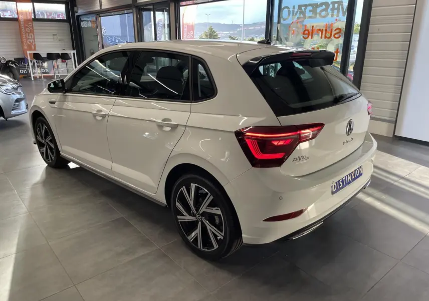 Vue 3/4 arrière droite de la Volkswagen Polo blanche 2024 R-Line avec jantes alliage et feux LED distinctifs.