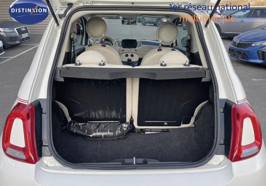 Vue arrière ouverte d'une FIAT 500 blanche 2022, montrant le coffre vide et l'intérieur clair avec sièges en cuir blanc.