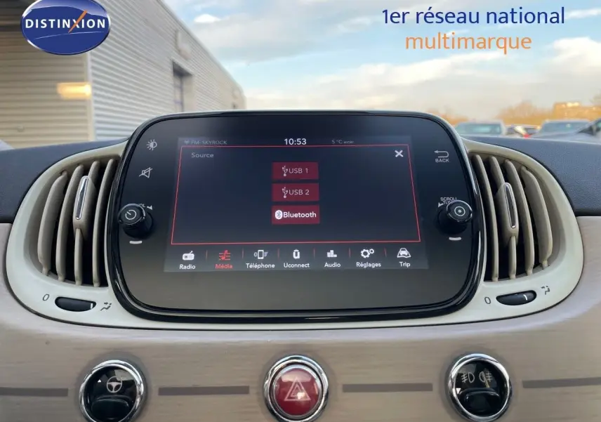 Écran tactile central affichant les options USB et Bluetooth dans l'habitacle beige clair d'une Fiat 500 blanche.