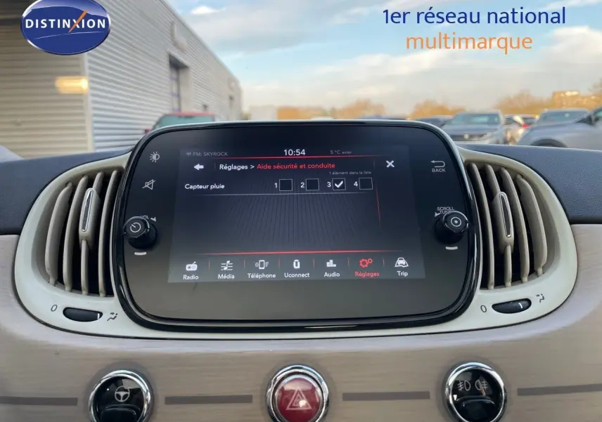 Écran tactile central avec réglages d'aide à la conduite dans l'habitacle clair d'une Fiat 500 blanche 2022.