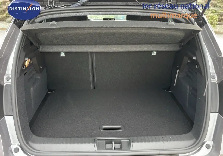 Coffre ouvert du Renault Captur E-Tech Hybrid 2025 gris Cassiopée métal avec toit noir, vue arrière détaillée.