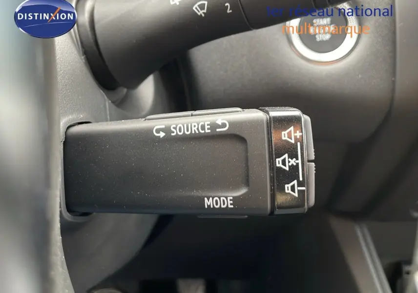 Gros plan sur la commande de source audio et mode du Renault Captur E-Tech gris Cassiopée avec toit noir, intérieur noir.