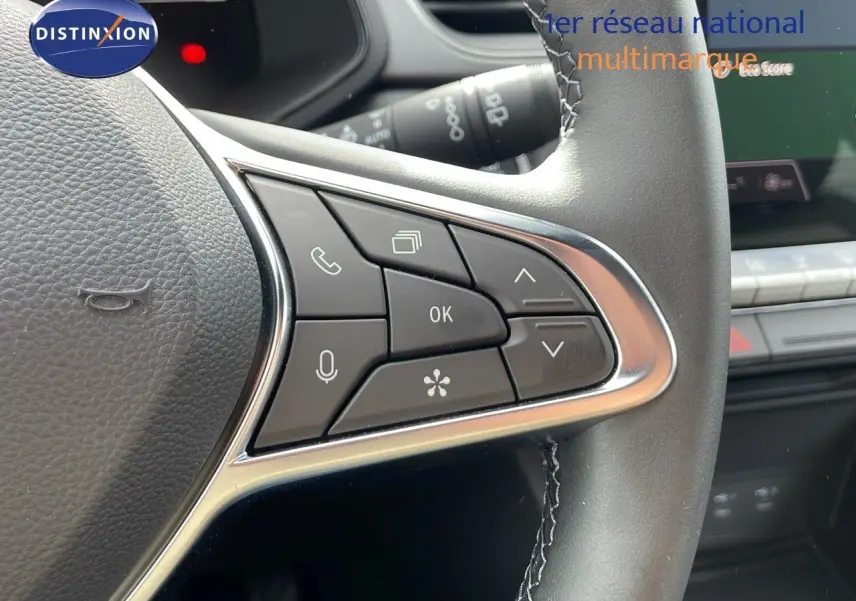 Gros plan sur les commandes au volant du Renault Captur E-Tech hybride 2025, intérieur noir avec détails argentés.
