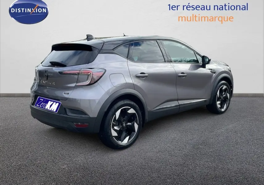 Vue 3/4 arrière droite du Renault Captur E-Tech gris Cassiopée avec toit noir et jantes bicolores.