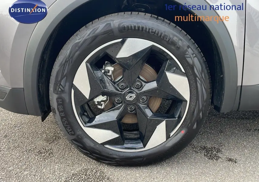 Gros plan sur la roue avant gauche du Renault Captur E-Tech gris Cassiopée avec jante noire et argentée en étoile.
