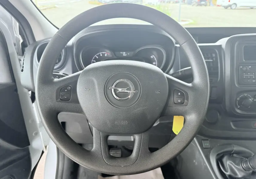 Vue centrée sur le volant noir de l'Opel Vivaro 2018, avec tableau de bord et levier de vitesses manuelle visibles.