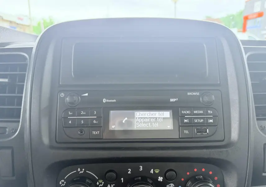 Vue rapprochée du tableau de bord noir de l’Opel Vivaro 2018, avec système audio et commandes de climatisation.
