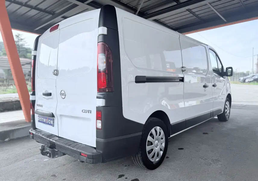 Vue 3/4 arrière droite d’un Opel Vivaro blanc diesel avec hayon et attelage sous abri.