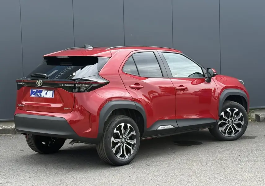 Vue 3/4 arrière droite d'une Toyota Yaris Cross rouge intense avec jantes alliage et détails noirs contrastants.