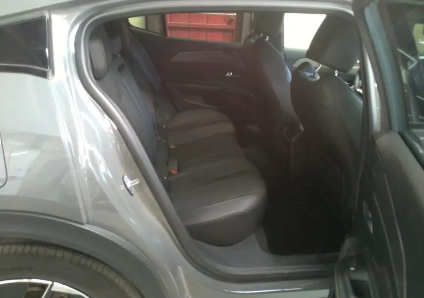 Vue côté gauche arrière du Peugeot 408 Hybrid 145 GT gris Selenium, montrant les sièges arrière en cuir noir.