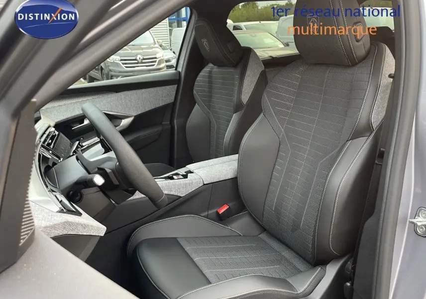 Intérieur avant droit du Peugeot 5008 gris Artense, sièges mixtes tissu et cuir noir avec logo GT brodé sur appuie-tête.