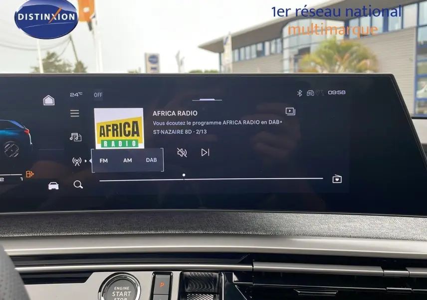 Vue intérieure du tableau de bord du Peugeot 5008 Hybrid gris Artense, écran tactile affichant Africa Radio en DAB