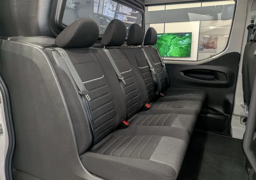 Banquette arrière en tissu noir vue de côté droit dans un Iveco Daily Fourgon blanc 2025, avec ceinture de sécurité visible.