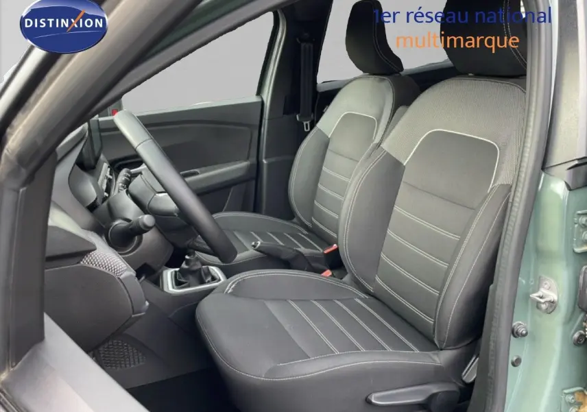 Vue intérieure côté conducteur du Dacia Jogger 2025 kaki lichen, montrant les sièges avant en tissu noir et gris.