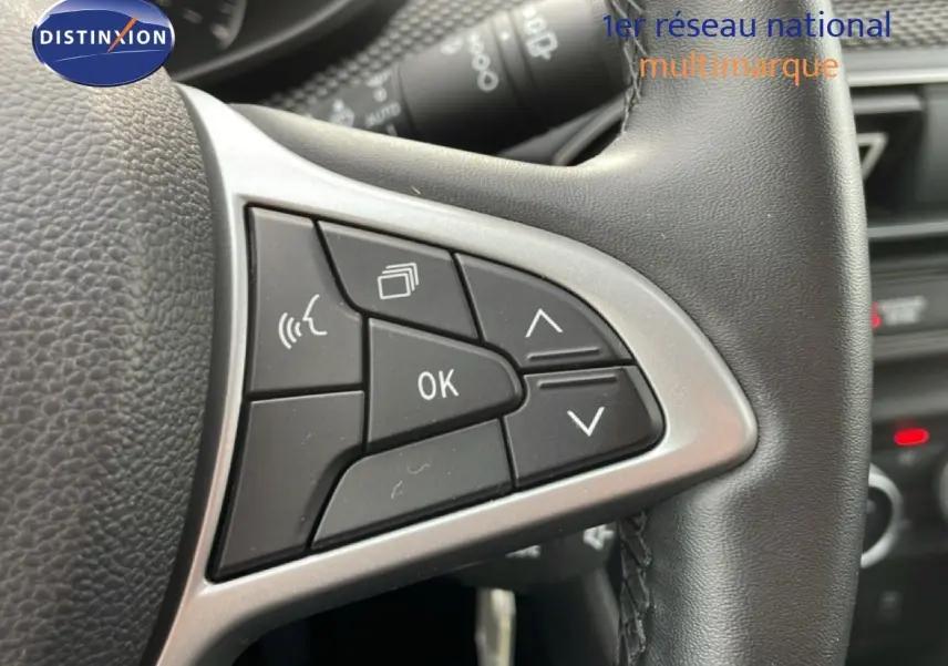 Gros plan sur les commandes au volant droit en cuir noir du Dacia Jogger 2025, version Expression kaki lichen.