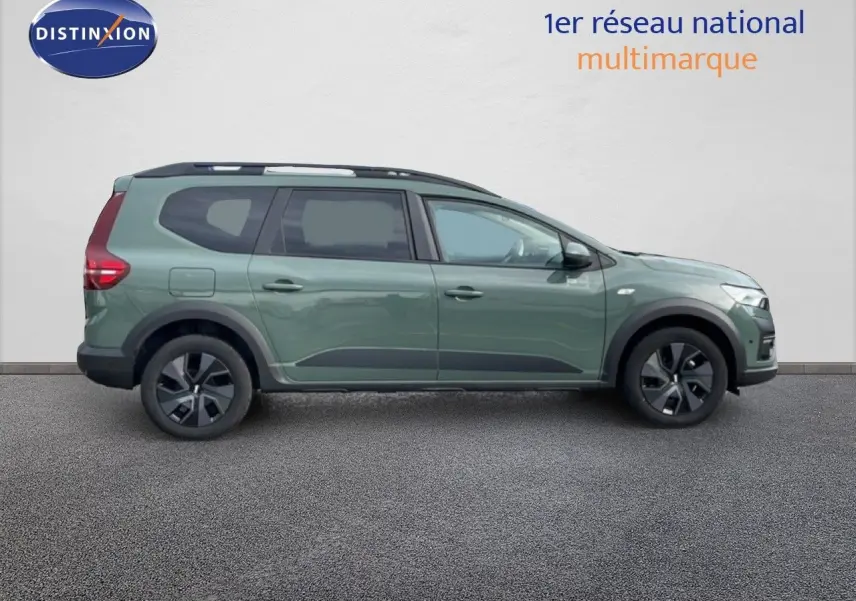 Profil droit du Dacia Jogger 2025 en kaki lichen, avec jantes noires et barres de toit visibles.