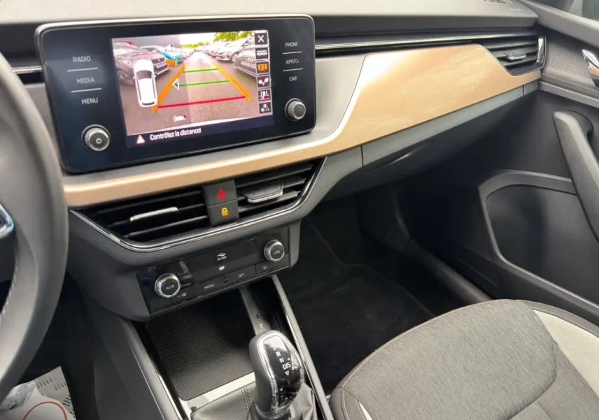 Vue intérieure du tableau de bord et console centrale du Skoda Kamiq 2023 avec écran tactile affichant la caméra de recul.