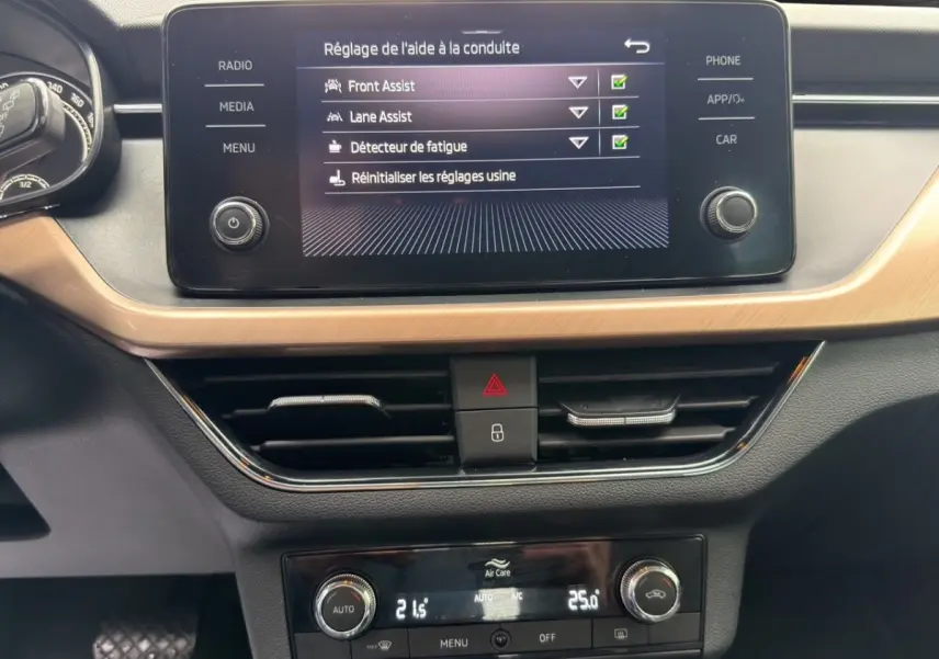 Écran tactile central affichant les aides à la conduite dans l’habitacle du Skoda Kamiq gris foncé.