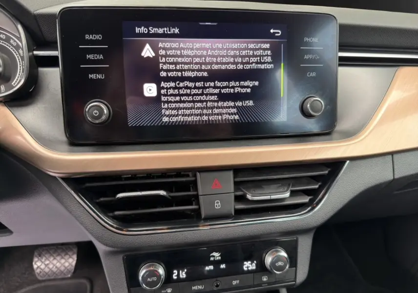 Vue rapprochée du tableau de bord du Skoda Kamiq 2023, écran tactile central affichant SmartLink, finition bois clair.