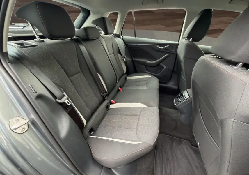 Vue intérieure arrière côté gauche du Skoda Kamiq gris foncé, sièges tissu bi-ton avec surpiqûres orange.