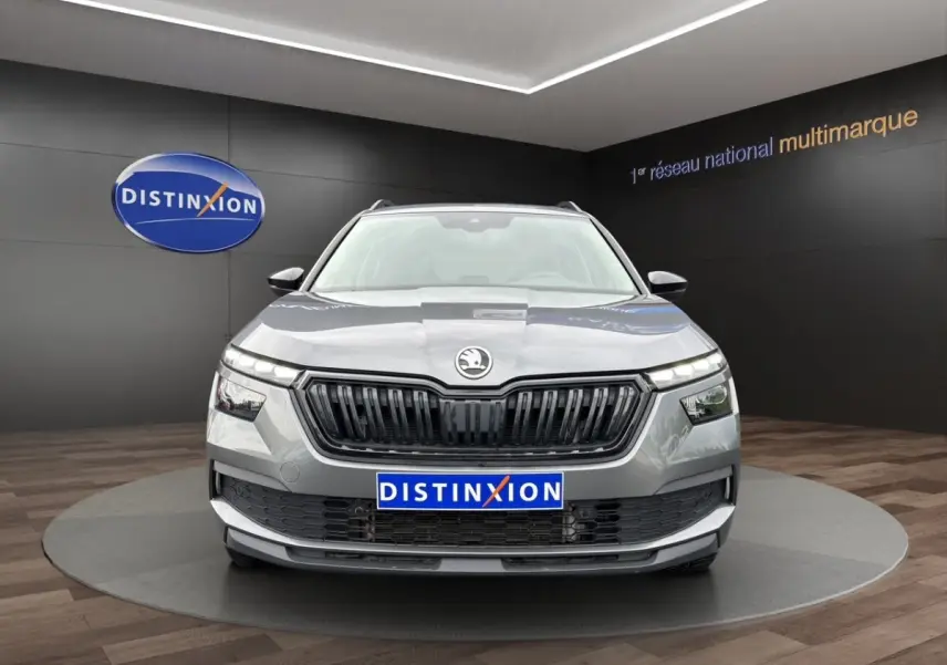Vue avant d'un Skoda Kamiq gris foncé avec calandre noire et logo centré, présenté en showroom Distinxion.