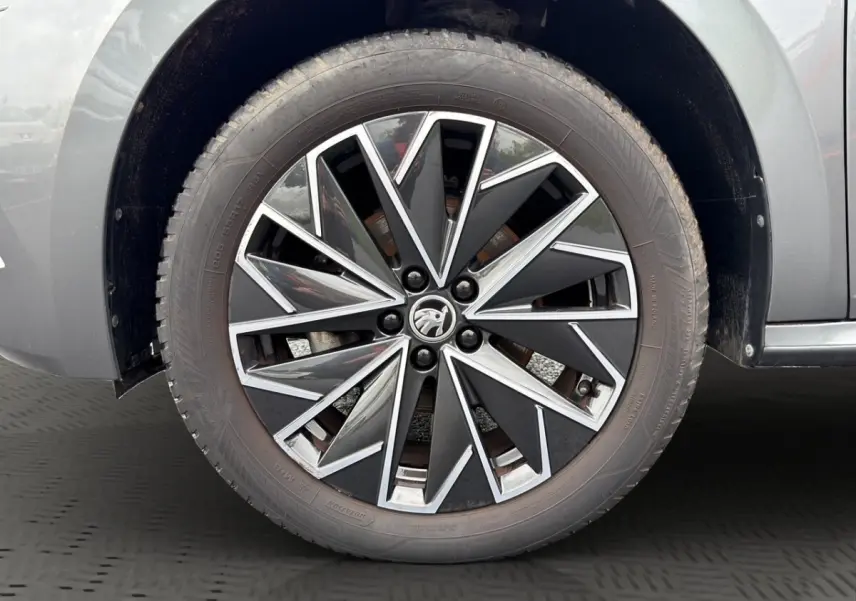 Gros plan sur la jante bi-ton noire et argent du côté gauche d’un Skoda Kamiq gris foncé 2023.