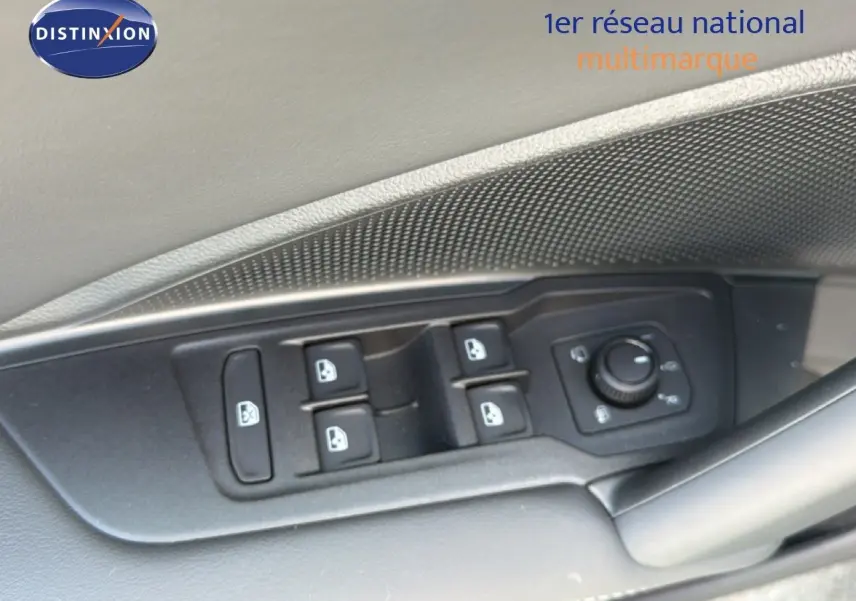 Gros plan sur les commandes des vitres et rétroviseurs côté conducteur d’un Volkswagen Tiguan gris dauphin métal.
