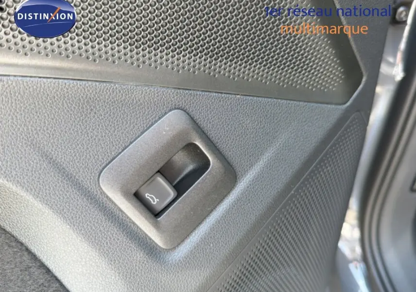 Gros plan sur le bouton d'ouverture du coffre côté gauche d'un Volkswagen Tiguan gris dauphin métal 2026.