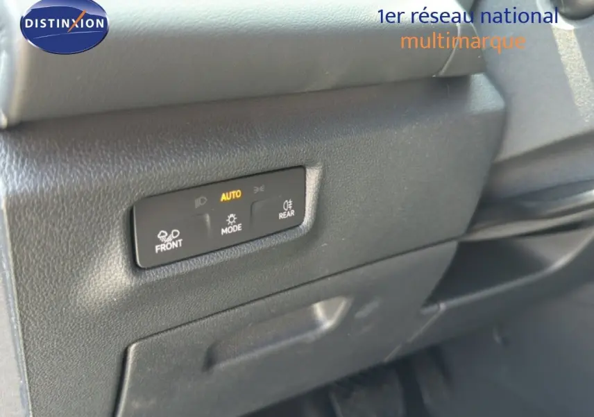 Détail du tableau de bord noir du Volkswagen Tiguan 2026 avec commandes d’éclairage automatiques visibles.