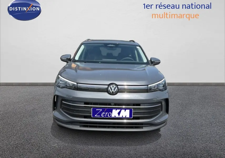 Vue avant d'un Volkswagen Tiguan gris dauphin métal 2026 avec calandre large et logo VW centré.
